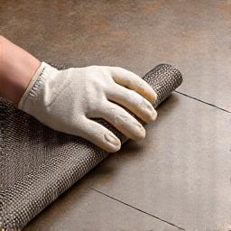 Electric radiant heating mat being unrolled for installation