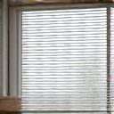 Automated smart blinds gracefully descending over a large window with natural light